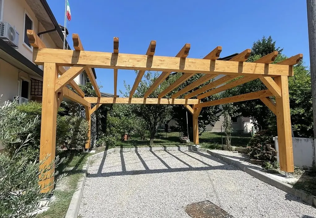 Pergola carport in legno lamellare montata da GSM in un giardino in provincia di Vicenza