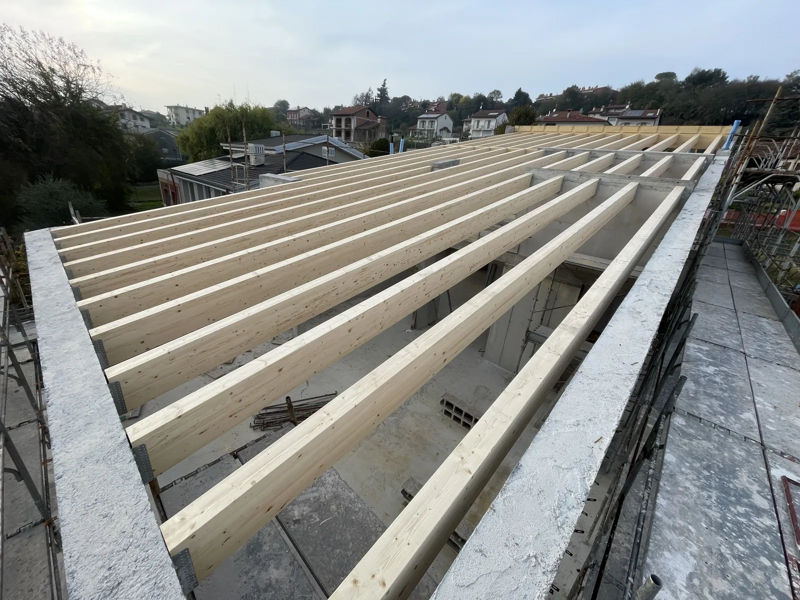 Struttura di un tetto con travi in legno lamellare posate da GSM su un edificio in costruzione in provincia di Vicenza