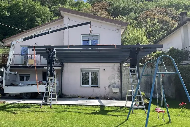 Montaggio di una pergola in acciaio nero addossata a un'abitazione