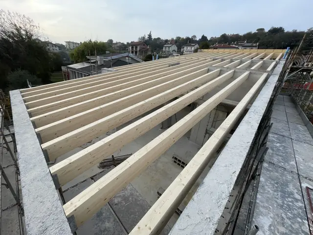 Struttura di un tetto con travi in legno lamellare posate da GSM su un edificio in costruzione in provincia di Vicenza