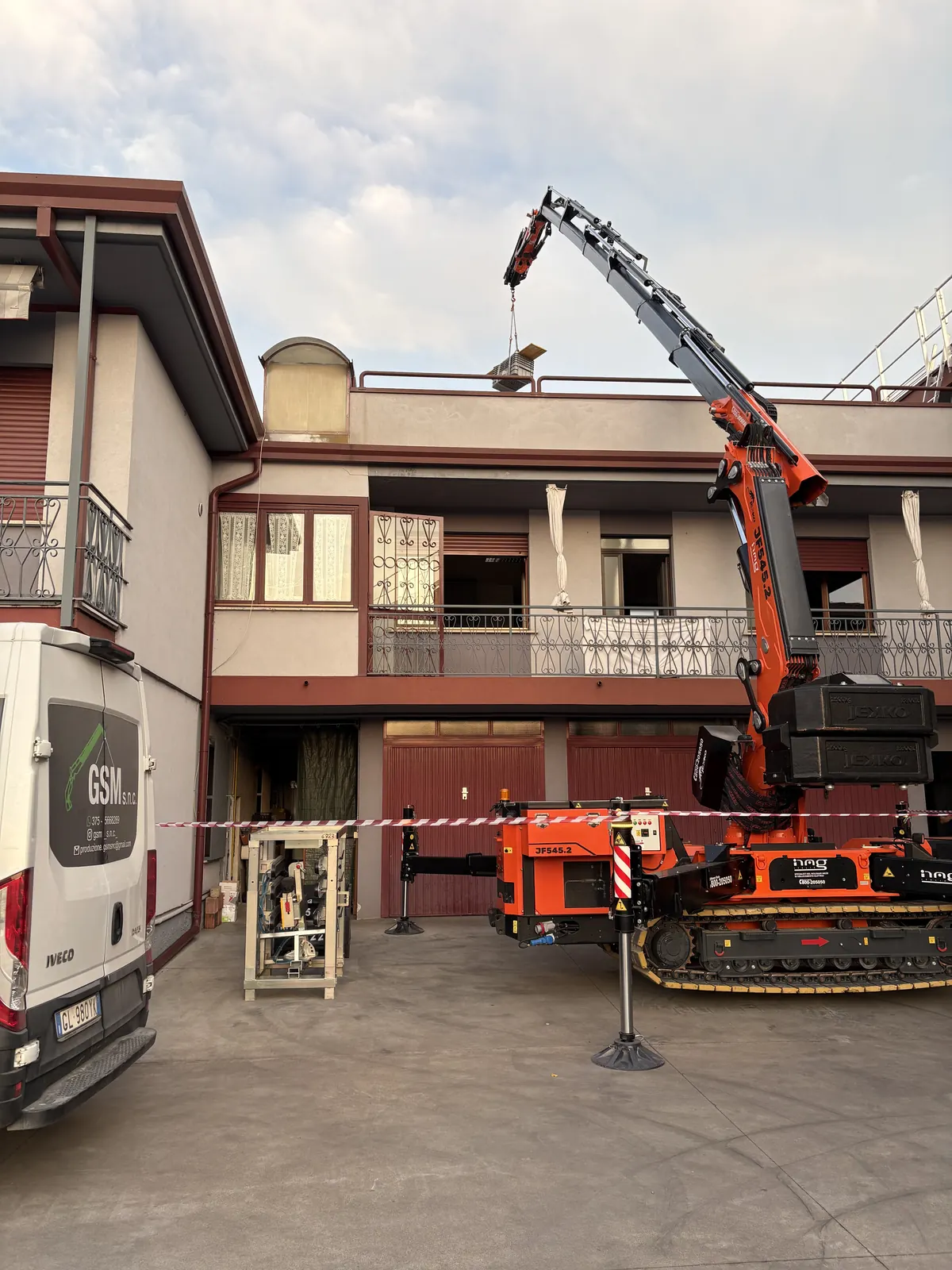 Gru ragno cingolata GSM in azione durante un sollevamento verso un terrazzo, in provincia di Vicenza